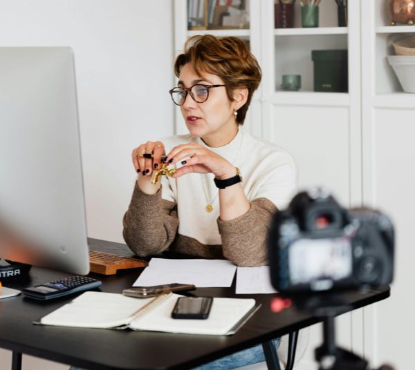 Woman at desktop computer with camera recording